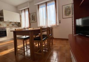 una cocina con una mesa de madera con sillas y un televisor en Hotel Marvin, en Montepulciano