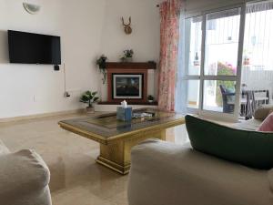 sala de estar con mesa de centro y TV en Benavista Estepona - 2 Bed Town House with Pool, en Estepona