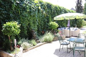 eine Terrasse mit einem Tisch, Stühlen und einem Sonnenschirm in der Unterkunft Pension Daniela Steiner in Podersdorf am See