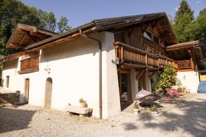 ein Haus mit einem Holzdach und einer Veranda in der Unterkunft Ferme de Faustine 2 - piscine in Saint-Gervais-les-Bains