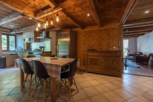 eine Küche und ein Esszimmer mit einem Holztisch und Stühlen in der Unterkunft Ferme de Faustine 2 - piscine in Saint-Gervais-les-Bains