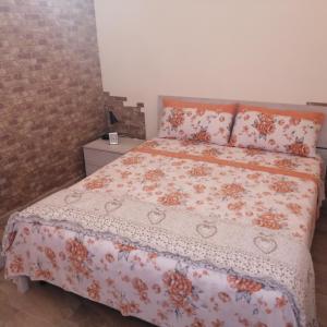 - une chambre dotée d'un lit avec un couvre-lit floral dans l'établissement Dimora Genovesi, à Catane