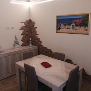 une table à manger avec des chaises et un tableau mural dans l'établissement Dimora Genovesi, à Catane