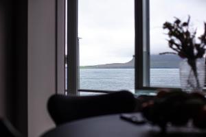 a room with a window with a view of the water at Hotel Djurhuus in Tórshavn