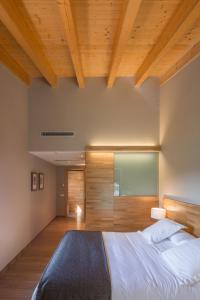 a bedroom with a large bed and wooden ceilings at Les Planes del Grau in Sant Joan de les Abadesses