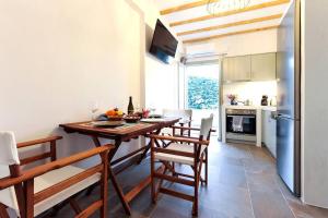 een keuken met een tafel en stoelen in een kamer bij Droufakos’ home - Beachfront Lux 2BD apt. w. Views in Sifnos