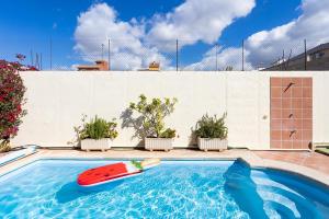 a swimming pool with a red surfboard in it at Casa Melocoton - Private pool - Ocean View - BBQ - Garden - Terrace - Free Wifi - Child & Pet-Friendly - 4 bedrooms - 8 people in La Listada