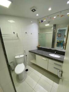 a bathroom with a toilet and a sink and a mirror at Carneiros Beach Resort Flat in Tamandaré