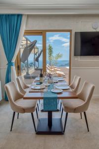a dining room with a table and chairs and a television at Quercus Residences Apartments in Sveti Stefan