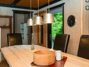 Vemb的住宿－6 person holiday home in Vemb，餐桌、椅子和墙上的时钟