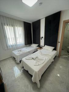una camera con due letti in una stanza con finestra di Didim Elit Otel a Didim