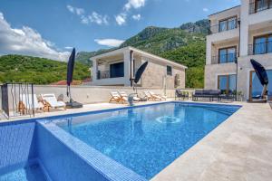 a villa with a swimming pool and a house at Quercus Residences Apartments in Sveti Stefan