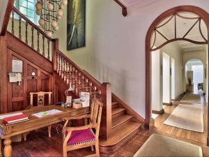 un comedor con una mesa de madera y escaleras en The Walden Suites, en Ciudad del Cabo