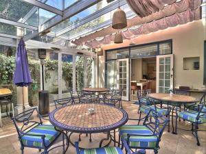 an outdoor patio with tables and chairs and windows at The Walden Suites in Cape Town