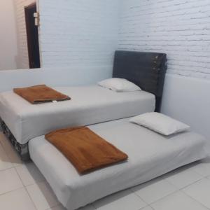 2 Betten mit Handtüchern auf einem Zimmer in der Unterkunft Toraja ManuBackPacker in Rantepao