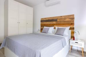 Dormitorio blanco con cama grande y cabecero de madera en Sunny Side Central, en Dubrovnik