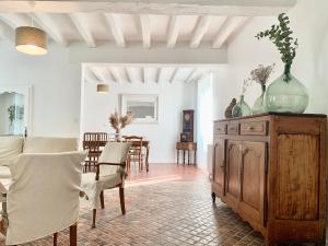 salon z wazą na górze drewnianej szafki w obiekcie Gîte Saint Expedit - Entre Zoo de Beauval et Chenonceaux w mieście Thésée