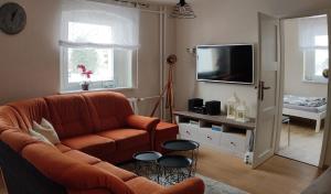 a living room with a couch and a television at Ferienwohnung Zum Ausblick in Kurort Altenberg