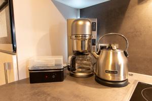 una macchinetta del caffè seduta su un bancone accanto a un mixer di Villa Bertha a Ostseebad Sellin Altre 9 foto