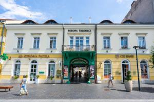 grupa ludzi przechodzących przed budynkiem w obiekcie Weissmann Residence w mieście Sopron