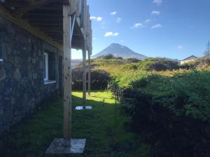einen Blick auf ein Haus mit einem Berg im Hintergrund in der Unterkunft Casa-do-Mar in Madalena