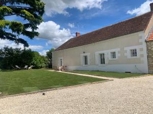 duży biały dom z trawnikiem w obiekcie Gîte Saint Expedit - Entre Zoo de Beauval et Chenonceaux w mieście Thésée