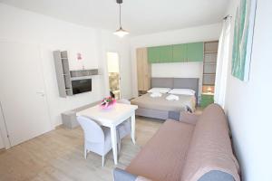 ein Wohnzimmer mit einem Bett und einem weißen Tisch in der Unterkunft Al Cuore di Valeggio in Valeggio sul Mincio