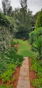 um jardim com um caminho de pedra e relva verde em VESA Guesthouse em Meyerton