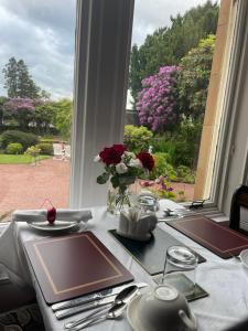 a table with a view of a garden from a window at Moorlands in Helensburgh