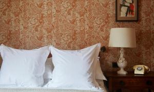 a bedroom with a bed with white pillows and a wall at The George In Rye in Rye