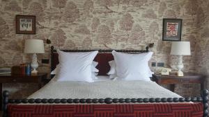a bedroom with a bed with white pillows and two lamps at The George In Rye in Rye