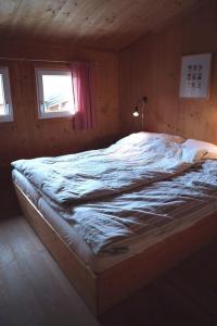 uma cama grande num quarto com duas janelas em Chalet Chocolat em Hohentauern