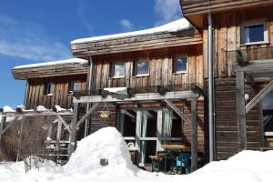domek z bali i śniegiem przed nim w obiekcie Chalet Chocolat w mieście Hohentauern