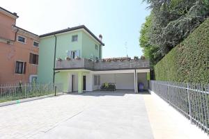ein grünes Haus mit Balkon darüber in der Unterkunft Al Cuore di Valeggio in Valeggio sul Mincio