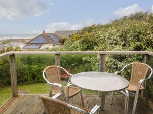 a table and chairs on a deck with a view at 7 Atlantic Close in Bude