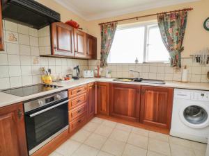 a kitchen with wooden cabinets and a dishwasher at 7 Atlantic Close in Bude