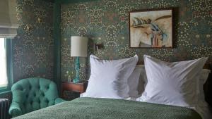 a bedroom with a bed and a blue chair at The George In Rye in Rye