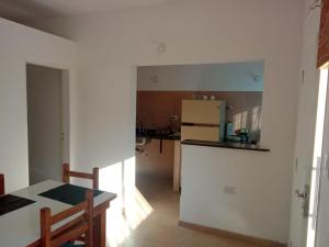 a kitchen with a table and a refrigerator at CENTENO CASI 9 DE JULIO in Santa Rosa