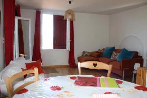 ein Wohnzimmer mit einem Sofa und einem Tisch in der Unterkunft À l'ombre du mûrier in Blauvac