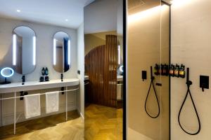 a bathroom with two mirrors and a shower at TRS Ibiza Hotel - Adults Only in San Antonio