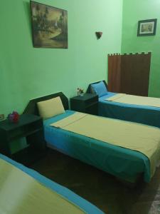 a room with two beds and a table and a bedvisor at African House Hostel in Cairo