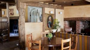 a dining room with a wooden table and a mirror at The George In Rye in Rye
