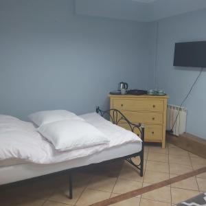 Strzegowo-OsadaにあるCottage Room- Agroturystykaのベッド(白いシーツ付)、ドレッサーが備わります。
