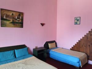 a room with two beds and a couch in it at African House Hostel in Cairo