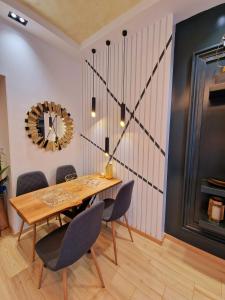 une salle à manger avec une table, des chaises et une horloge dans l'établissement FS Apartments Varna - Beautiful apartment in the center of Varna, à Varna