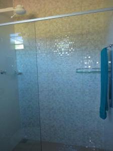 a bathroom with a shower with a glass door at Pousada Epicurista in Capitólio