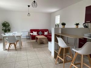 a living room with a red couch and a table at Sully-sur-loire: Agréable maison en centre ville in Sully-sur-Loire