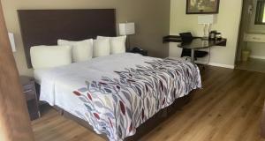 Pokój hotelowy z łóżkiem i biurkiem w obiekcie Red Roof Inn Clearfield w mieście Clearfield