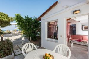 a table with a bowl of fruit on a patio at Rouladina Apartments in Stalos