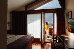 库马约尔Hotel Walser Courmayeur的走出卧室窗户的女人